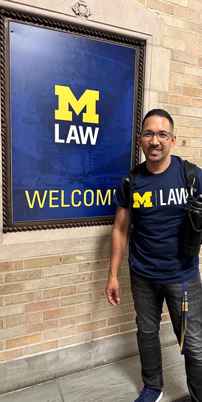 Ruben Pinuelas stands in front of a Michigan Law sign
